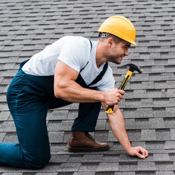 repairman-in-helmet-holding-hammer-while-repairing-2022-12-16-20-00-29-utc